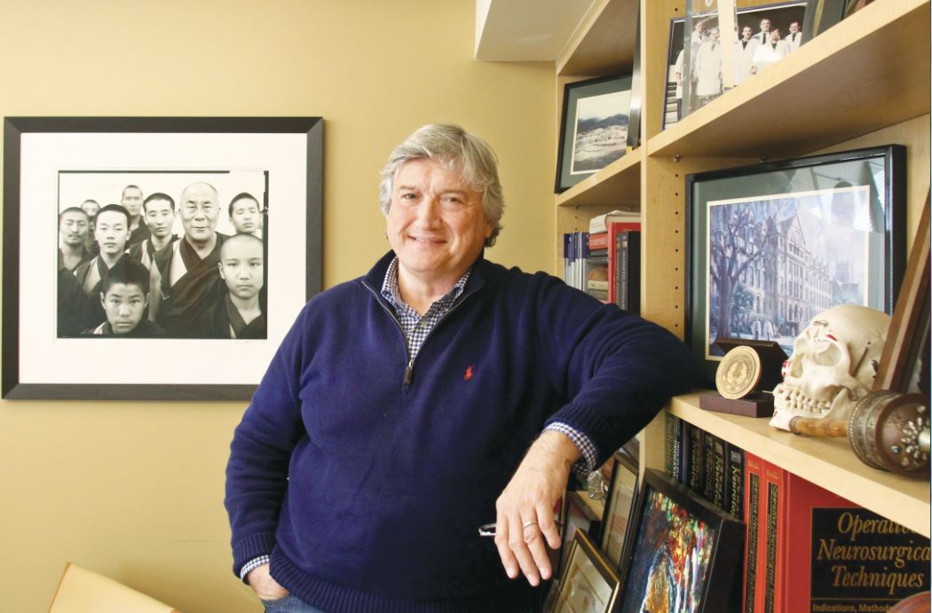 Man (Dr. James Doty) standing in a living room with a smile