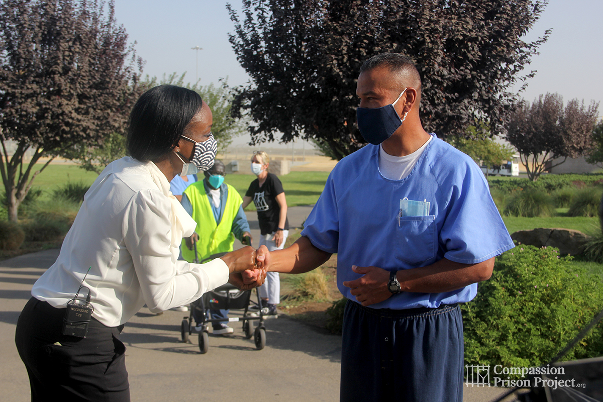 Nadine Burke Harris shaking hands with prison resident
